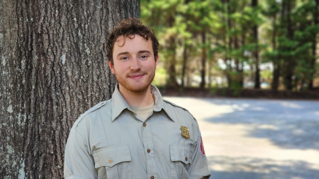 A young man in a forestry shirt.